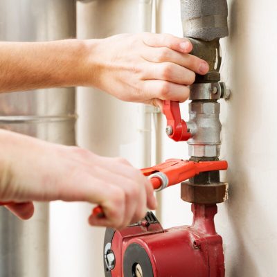 closeup of plumber hands working with pipeline connections
